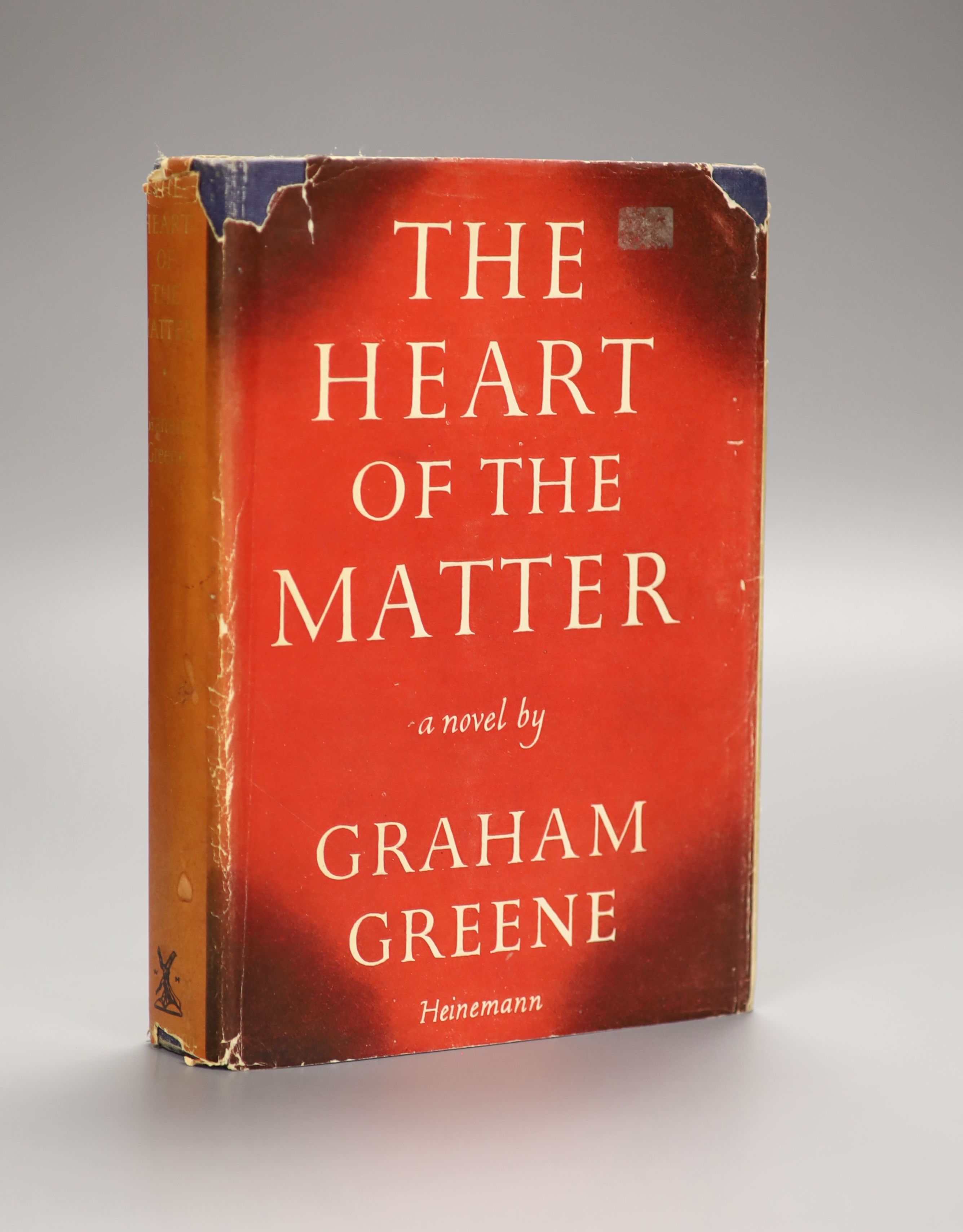 Greene, Graham - The Heart of the Matter, 1st edition, original blue cloth, in unclipped d/j with tears and loss, ink inscription to front fly leaf, text with occasional spotting,William Heinemann, London, 1948